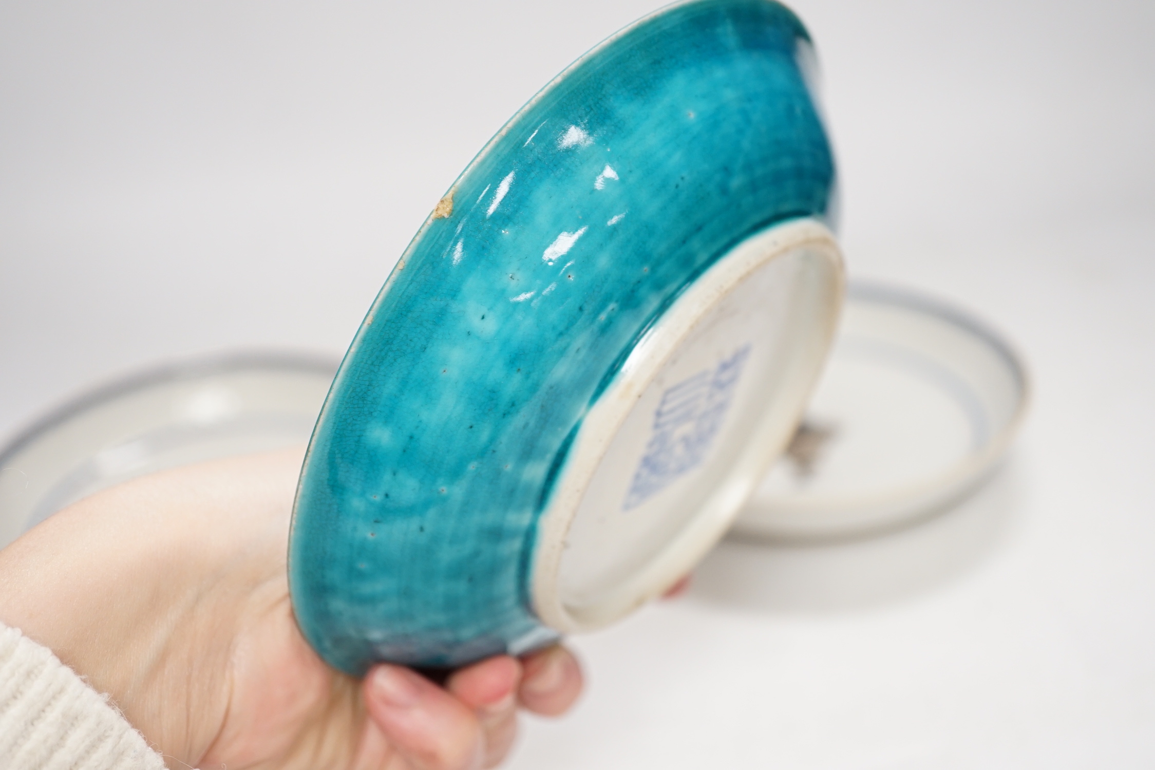 A Chinese turquoise glazed saucer dish, Qianlong Mark and period and two Chinese export famille rose saucers, Qianlong period, 16cm diameter